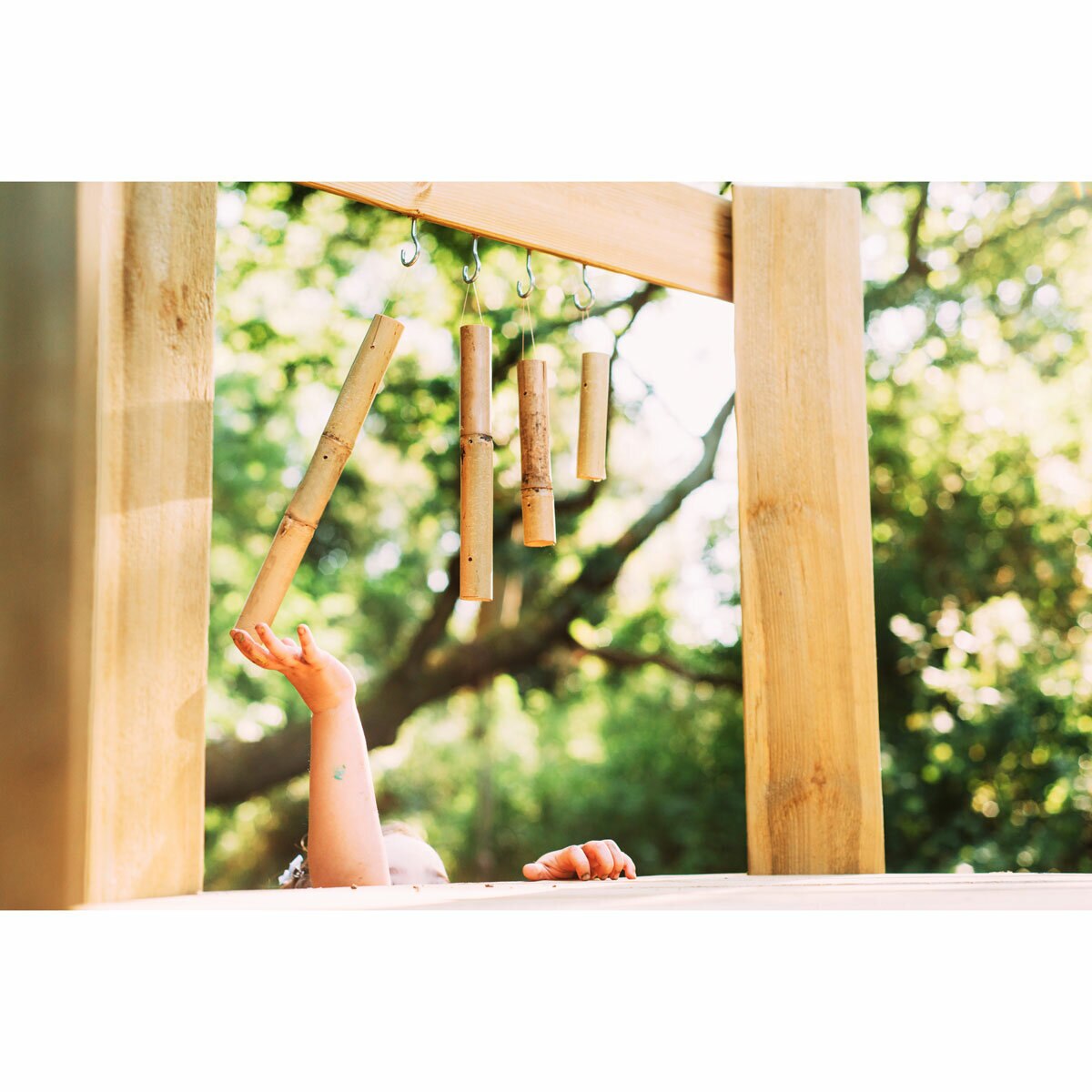 Lifestyle image of a child playing with the wind chimes Lifestyle image of a child playing with the wind chimes