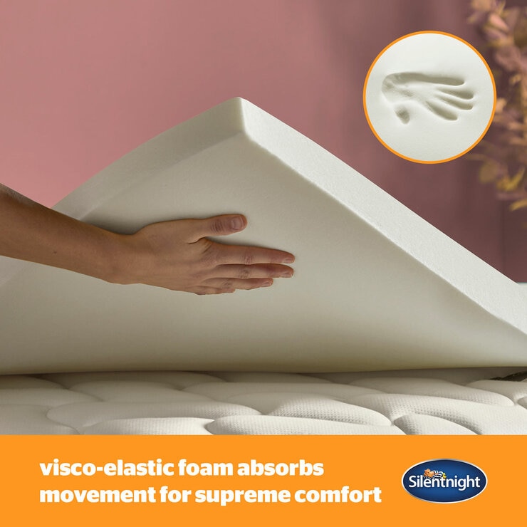 A white mattress topper with elastic corner straps fitted neatly over a mattress.