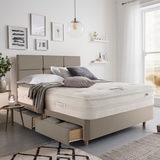Lifestyle image of made up bed in sandstone in front of window showing beachside