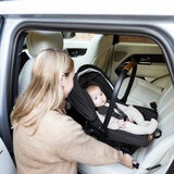 Lifestyle image of a woman putting the car seat into the car