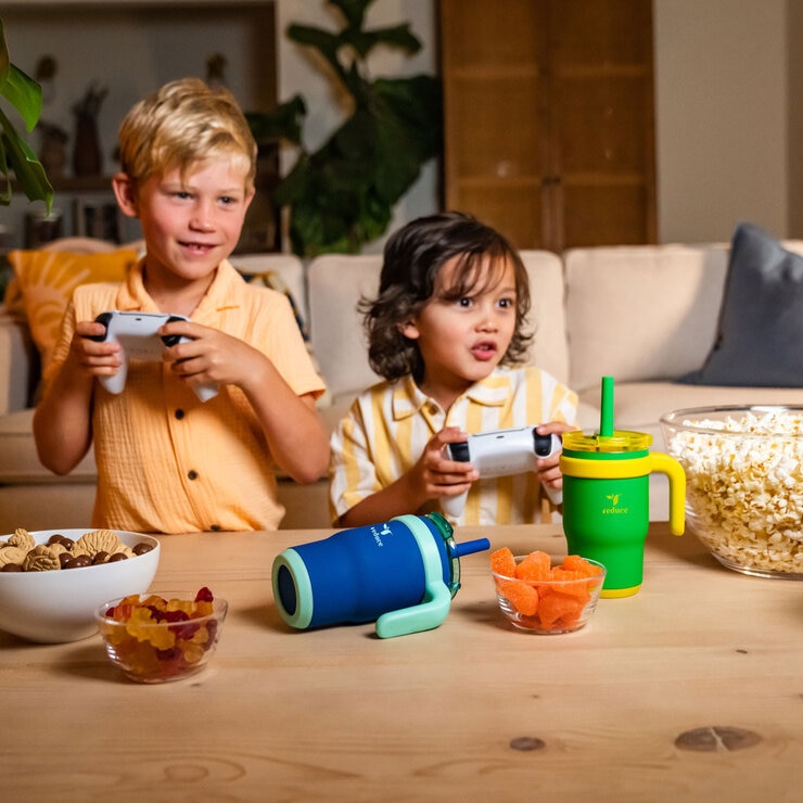 Two young boys playing ps5 with their Coldee bottles on the table