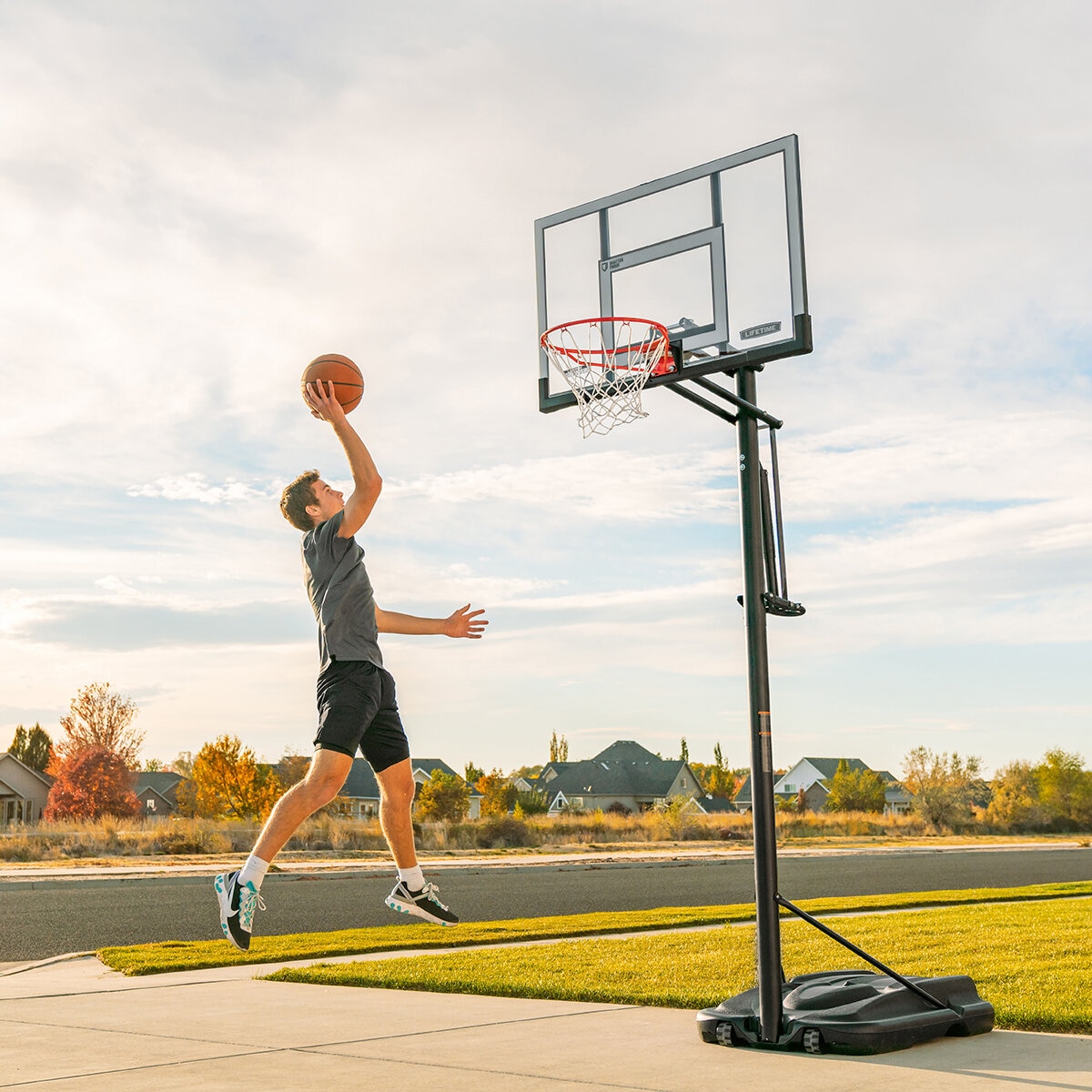 Lifestyle image of someone throwing a basketball into the Lifetime 52 Inch Portable Basketball Hoop System Lifestyle image of someone throwing a basketball into the Lifetime 52 Inch Portable Basketball Hoop System