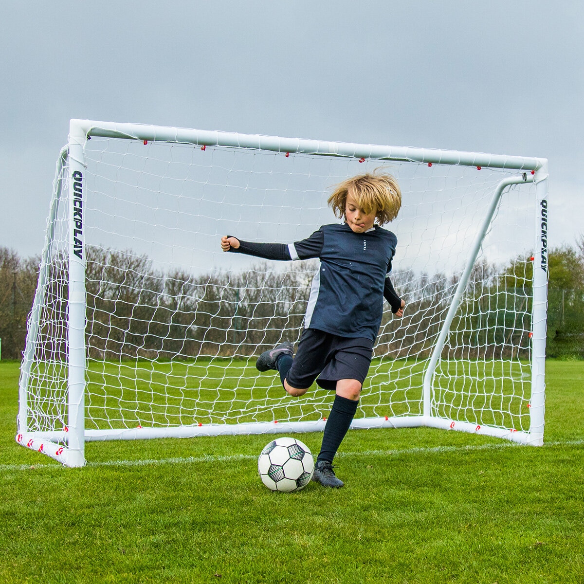 Lifestyle image of a goalkeeper kicking a football away from the goal