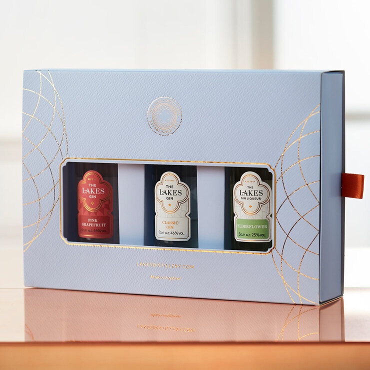 Giftpack of 3 gins in blue cardboard box set on table Giftpack of 3 gins in blue cardboard box set on table