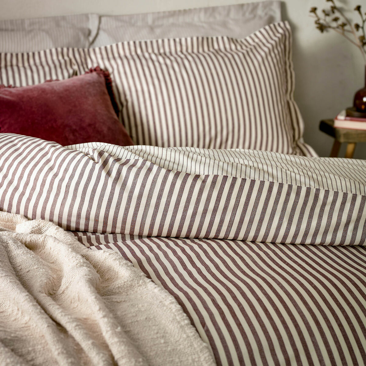 Striped duvet set with vertical burgundy and white lines, paired with matching pillowcases