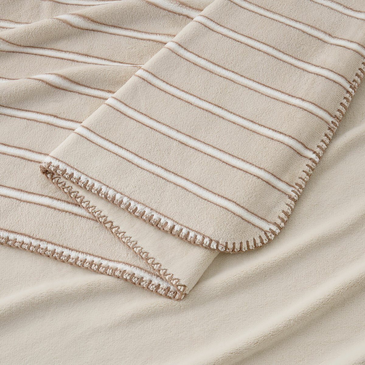 Taupe plaid throw zoomed in, soft plush look with outer edge thread trimming