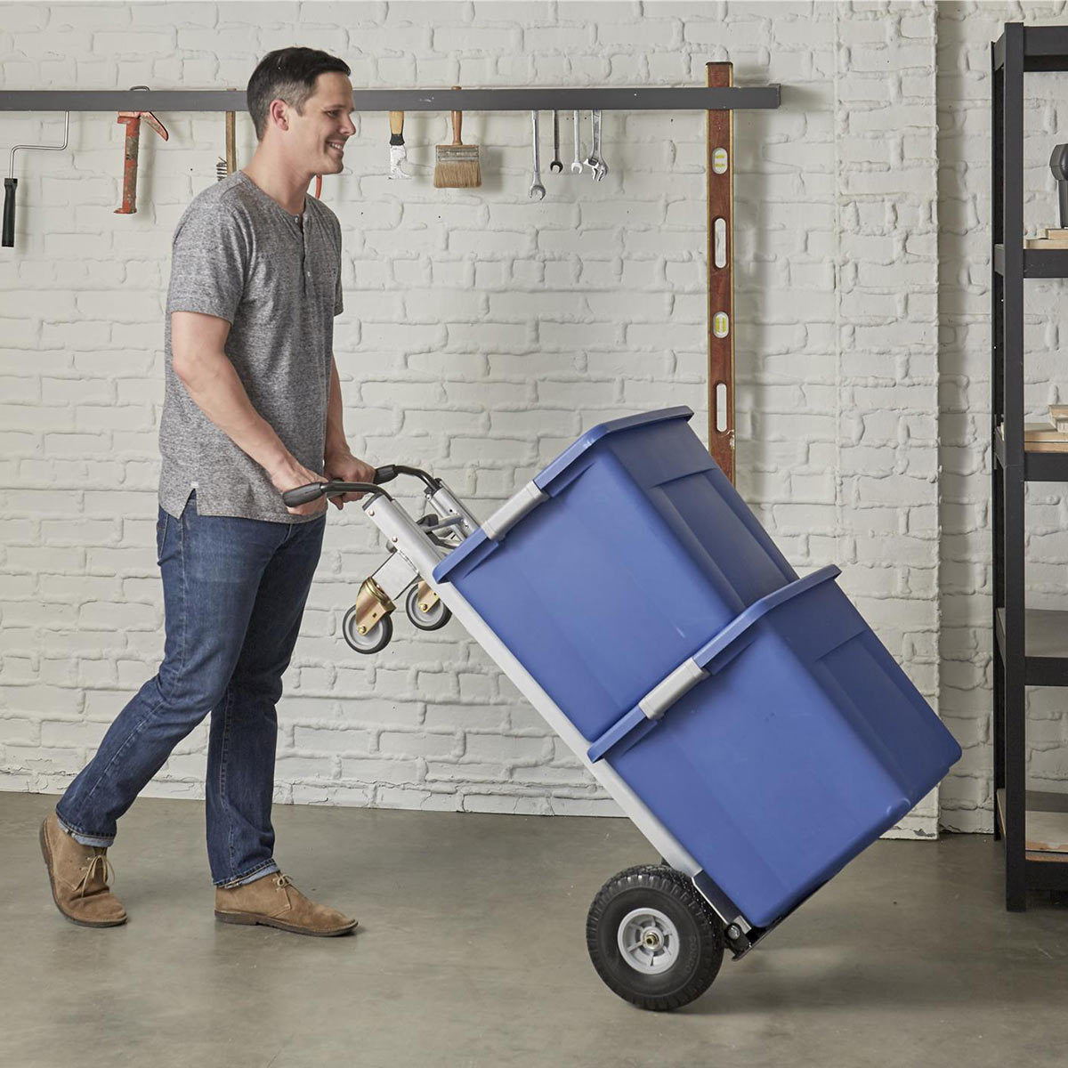 Man pushing hand truck upright loaded with boxes