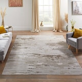 Large abstract rug in beige and grey tones, placed in a modern living room with minimal decor.