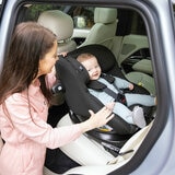 Lifestyle image of a mother putting child into the car