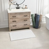 White bath mats with a textured surface and non‑slip backing White bath mats with a textured surface and non‑slip backing