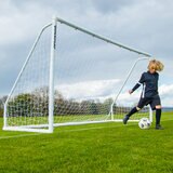 Lifestyle image of a goalkeeper kicking a football away from the goal