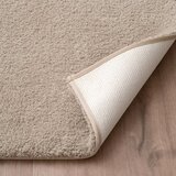 Zommed in imagery of Tan bath mat folded showcasing anti skid backing