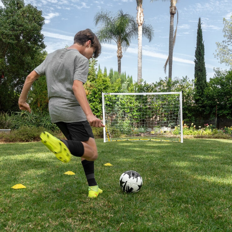 Lifestyle image of someone kicking a ball into the goal
