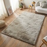 taupe-coloured fluffy textured rug on wooden floor taupe-coloured fluffy textured rug on wooden floor