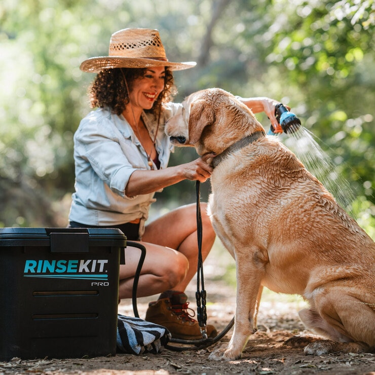 Lifestyle image showing someone washing their dog with the Rinsekit Pro