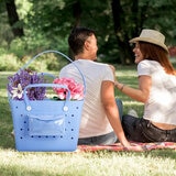 Lifestyle image of blue Beachcomber bag full of flowers Lifestyle image of blue Beachcomber bag full of flowers