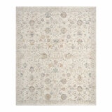 Beige rug with symmetrical floral and geometric pattern in muted blue, red, yellow, and grey