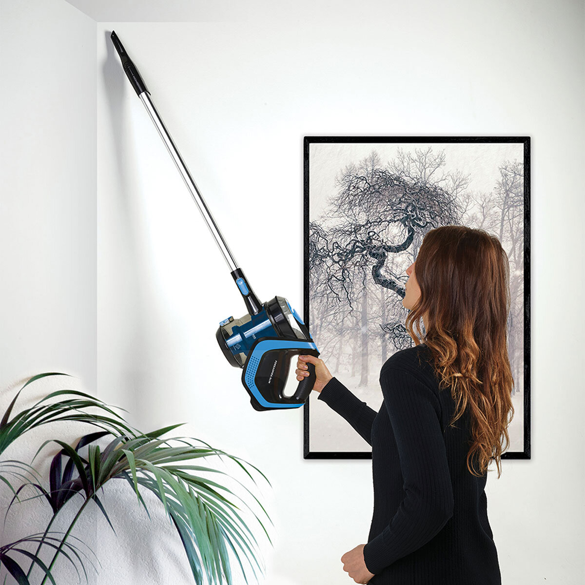 Lifestyle image of woman vacuuming ceiling with SR100