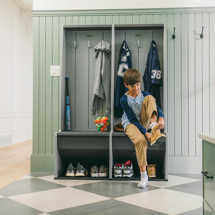 Lifestyle image showing a child putting his shoes on while sat on the locker Lifestyle image showing a child putting his shoes on while sat on the locker