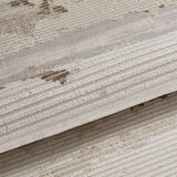 Close-up of a rolled ribbed rug in beige and cream with subtle darker accents.