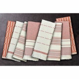 Set of eight folded woven tea towels in red, pink and white stripes and checks, displayed side by side to highlight their varied textures.