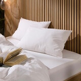 Two white pillows against a wooden headboard Two white pillows against a wooden headboard