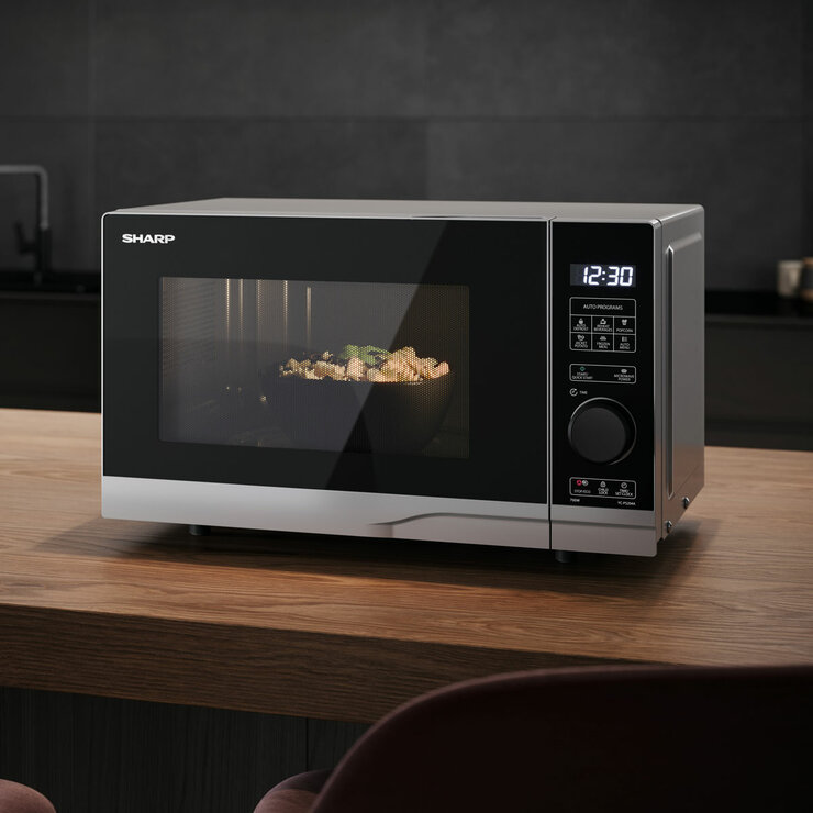 Lifestyle image of Sharp Compact 20 Litre 700W Solo Digital Microwave heating up food