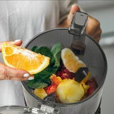 Lifestyle image of AUTO10S Juicer with smoothie ingredients inside