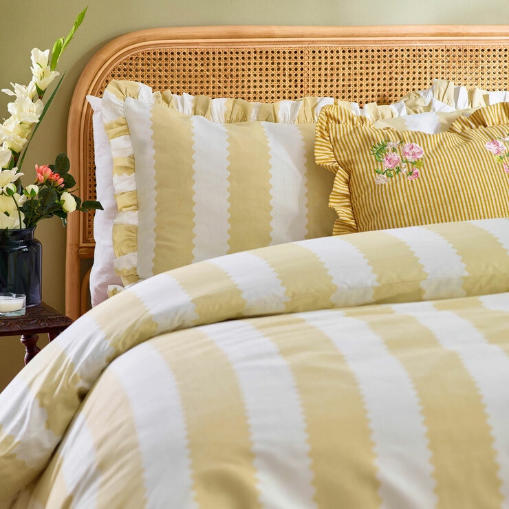 Yellow and white striped duvet set with scalloped detailing and matching pillow shams.