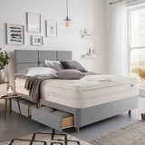 Lifestyle image of made up bed in slate in front of window showing beachside