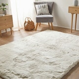 Cream-coloured fluffy textured rug on wooden floor