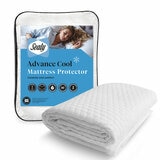 A fitted white mattress protector with a hexagonal quilted pattern on a neatly made bed in a modern bedroom