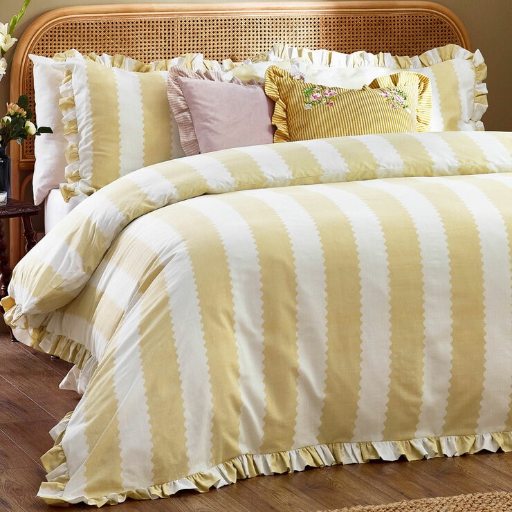 Yellow and white striped duvet set with scalloped detailing and matching pillow shams.