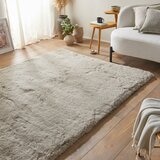 taupe-coloured fluffy textured rug on wooden floor taupe-coloured fluffy textured rug on wooden floor