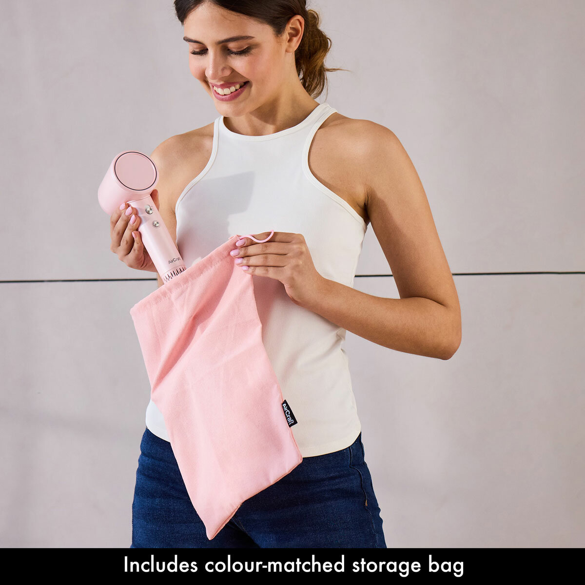 Lifestyle image of model putting the hair dryer into a storage bag