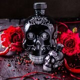 Kah Anejo Tequila Skull on a table with roses