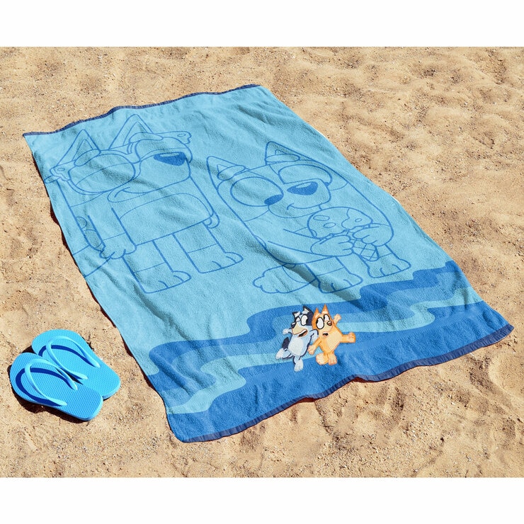 Bluey character beach towel laid out on sand