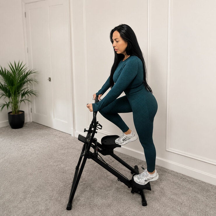 Lifestyle image of a woman using the stair climber