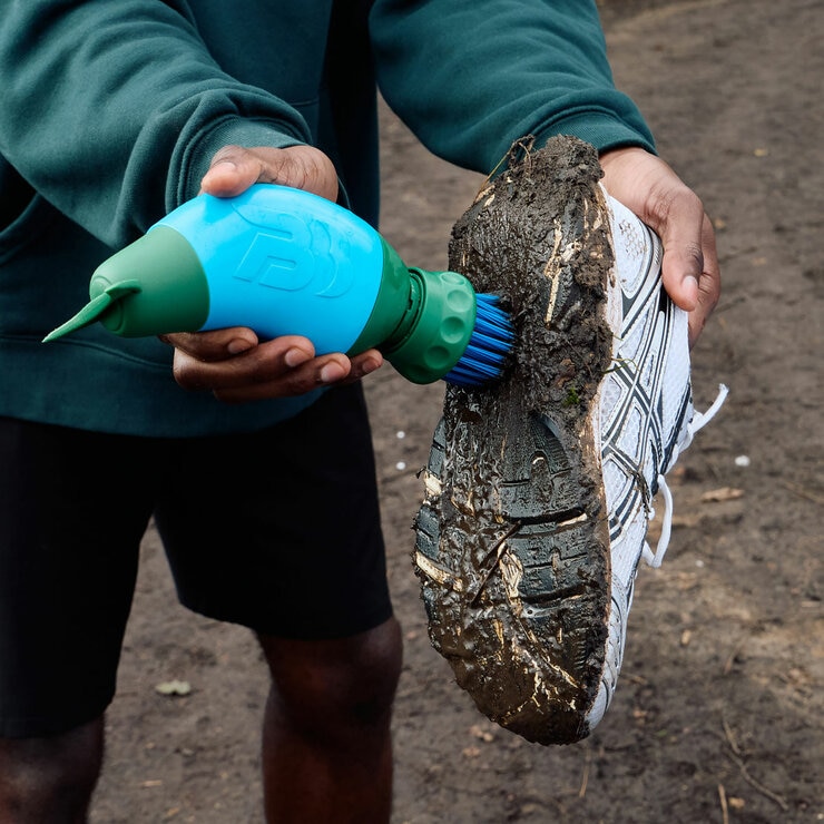 Lifestyle image of someone scrubbing their shoe