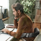 Lifestyle image of model using the massager on their back