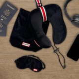 Black travel pillow with striped trim and matching black eye mask