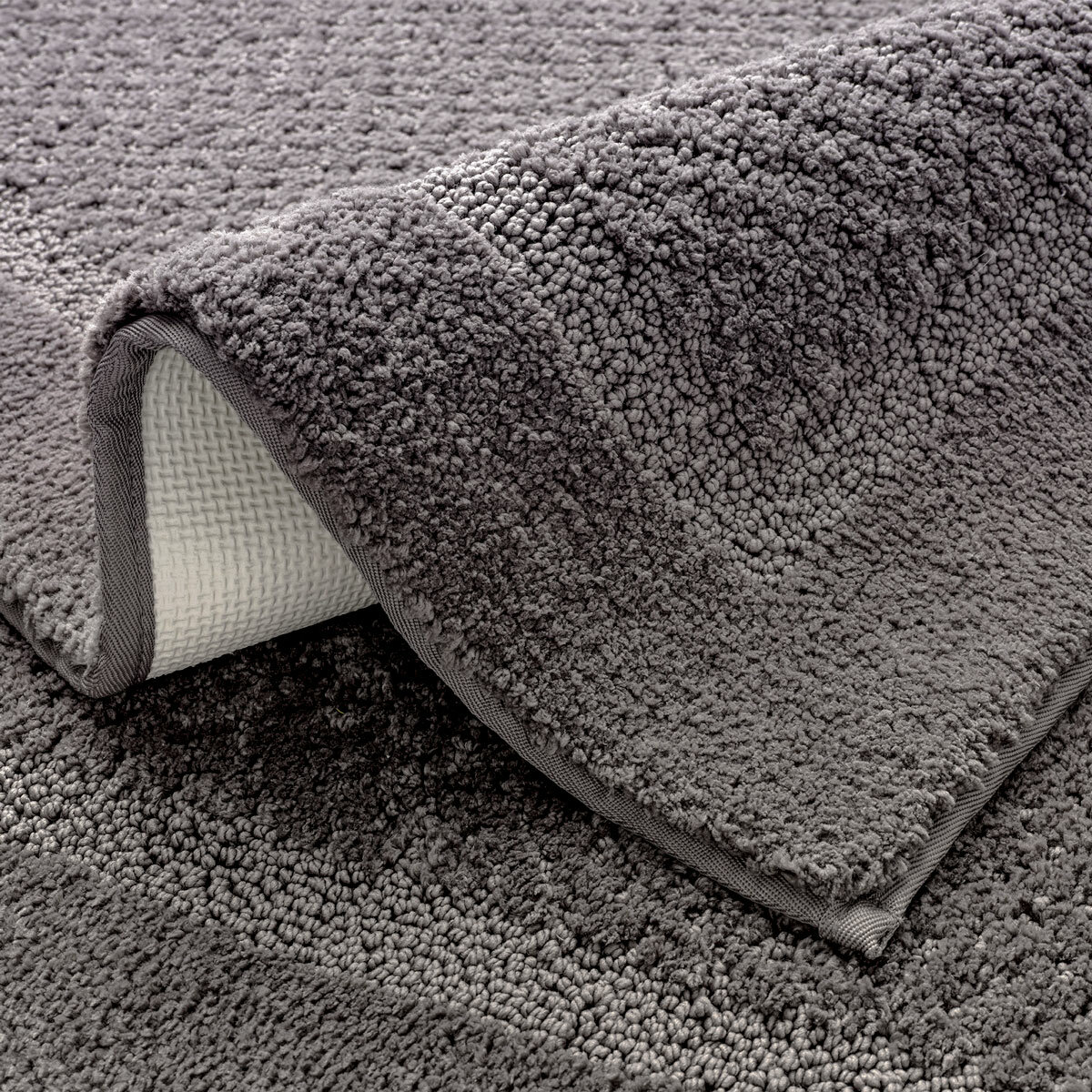 Grey bath mat with a textured surface and non‑slip backing Grey bath mat with a textured surface and non‑slip backing