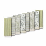Set of eight folded tea towels in green and neutral botanical and striped designs, arranged to showcase pattern and texture with a plain background