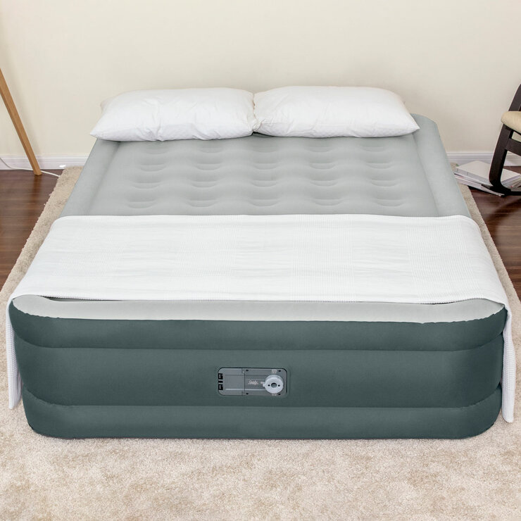 Lifestyle image of the airbed with pillows and a sheet on