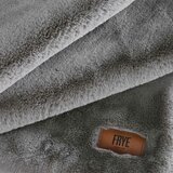 Close-up of soft grey faux fur throw with stitched leather brand tag