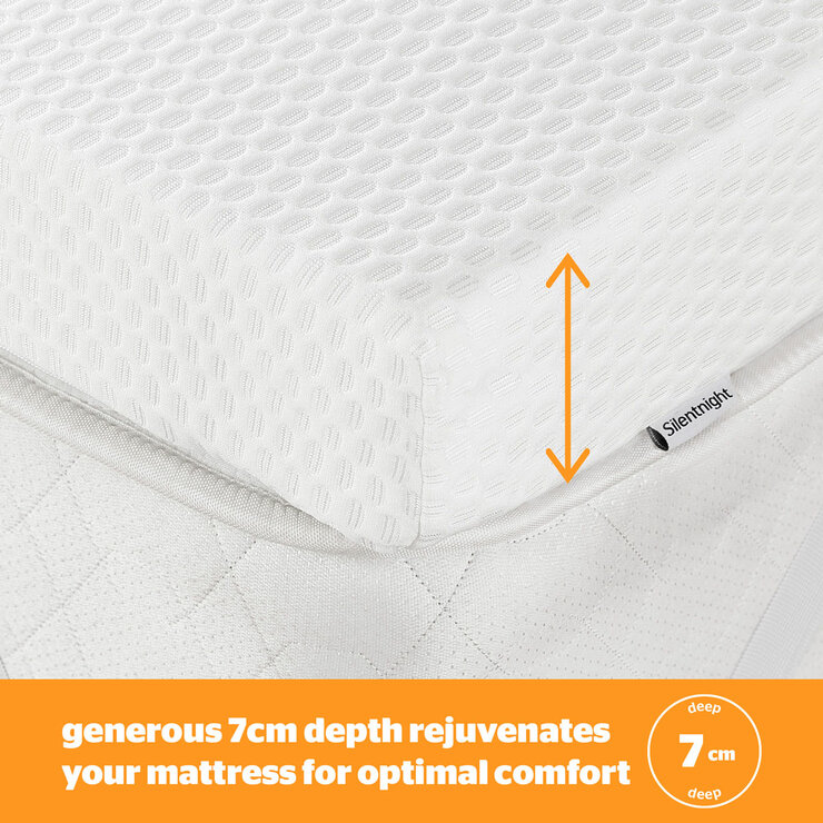 A white mattress topper with elastic corner straps fitted neatly over a mattress.