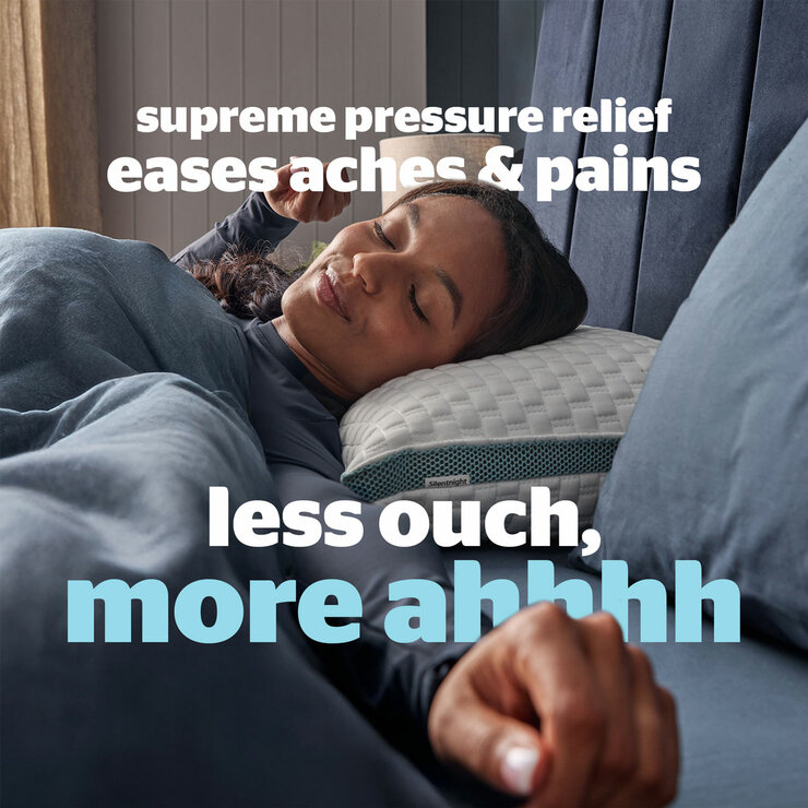 Person resting on Silentnight pillow in cozy bedroom, promoting supreme pressure relief and reduced aches.
