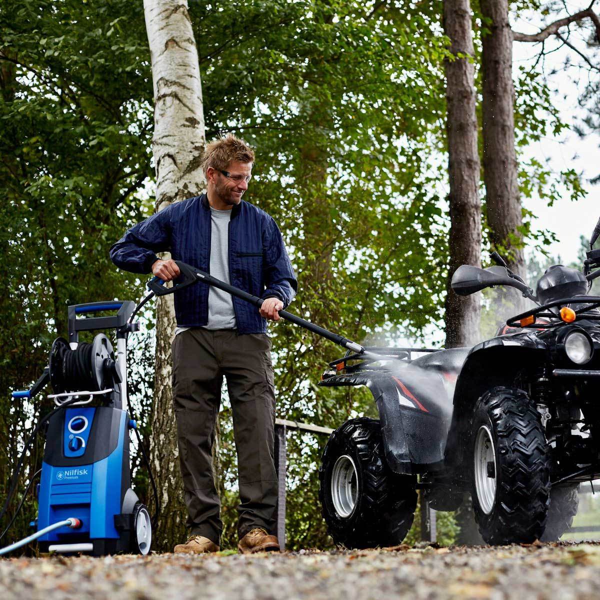Lifestyle image of pressure washer being used to clean ATV