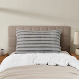 XL ribbed pillow with a plush texture propped against a tufted headboard on a neatly made bed