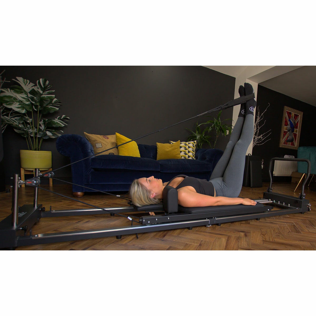 Lifestyle image of a woman using the reformer Lifestyle image of a woman using the reformer
